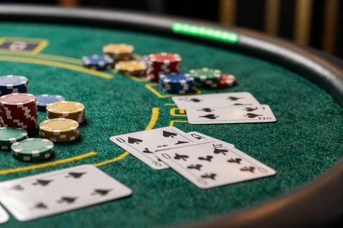 Gr&uuml;ner Blackjack-Tisch mit goldenen Chips und Karten im Neonlicht - Golazzo Blackjack spielen